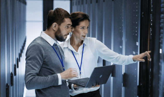 man and woman examining data center and pointing at something.